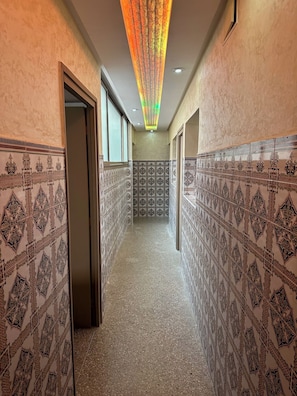 A hallway with patterned walls and a ceiling light fixture. - Fully equipped 80 m² apartment in Agadir, located in a house with a terrace. (agadir)
