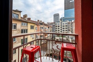 A balcony with a view of surrounding buildings, including a modern glass skyscraper. - NEW! Pink Lipstick Lounge Design look/Hotel feel (Sofia)
