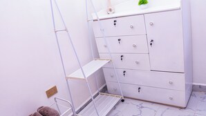 A white dresser with multiple drawers and a small plant on top.