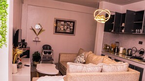 A compact living space with a kitchenette, a sofa set, a dining table, and a television. - Luxury Kimana Stay Near Amboseli (Kimana)