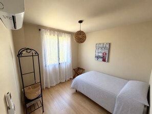 A bedroom with a bed, a window with sheer curtains, a hanging light fixture, and a wall-mounted artwork. - Provençal house with a private pool at the foot of Mont Ventoux—Vaison-la-Romaine (Vaison-la-Romaine)