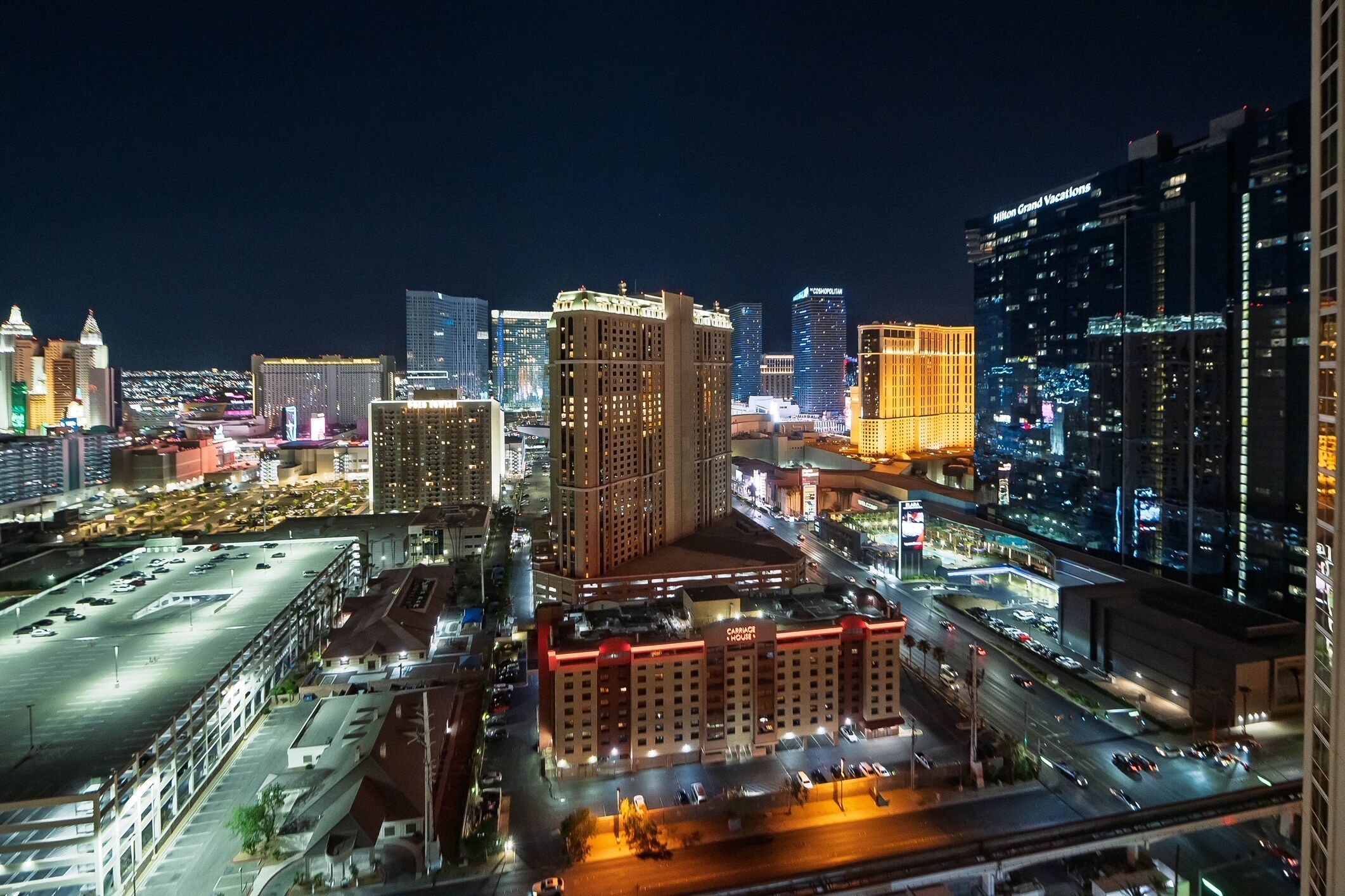 A cityscape at night with prominent buildings, including a hotel and a casino.