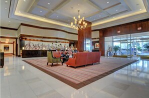 A spacious lobby with a reception desk, seating area, and a large chandelier. - Penthouse Suite MGM Signature Sphere  (Las Vegas)