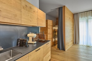 Eine moderne Küche mit Holzschränken, einer integrierten Espressomaschine und einer eleganten Arbeitsplatte.