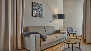 A modern living room with a sofa, a chair, a small round table, and a lamp. - 8005 Alpin Retreat Grand 5 (Schröcken)