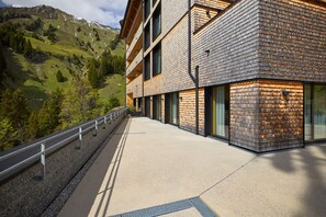 A modern building with a flat roof, large windows, and a paved walkway. - 8009 Arlberg Grand Residence 9 (Schröcken)