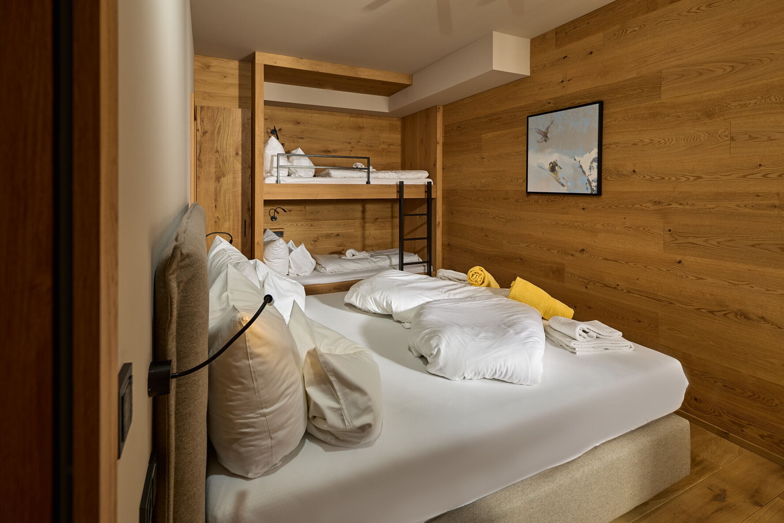 A bunk bed room with a wooden wall and a painting.