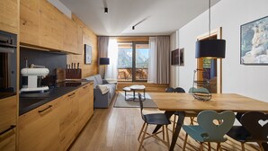 Eine moderne Küche mit Holzausstattung, einem eingebauten Backofen und einer Kaffeemaschine.