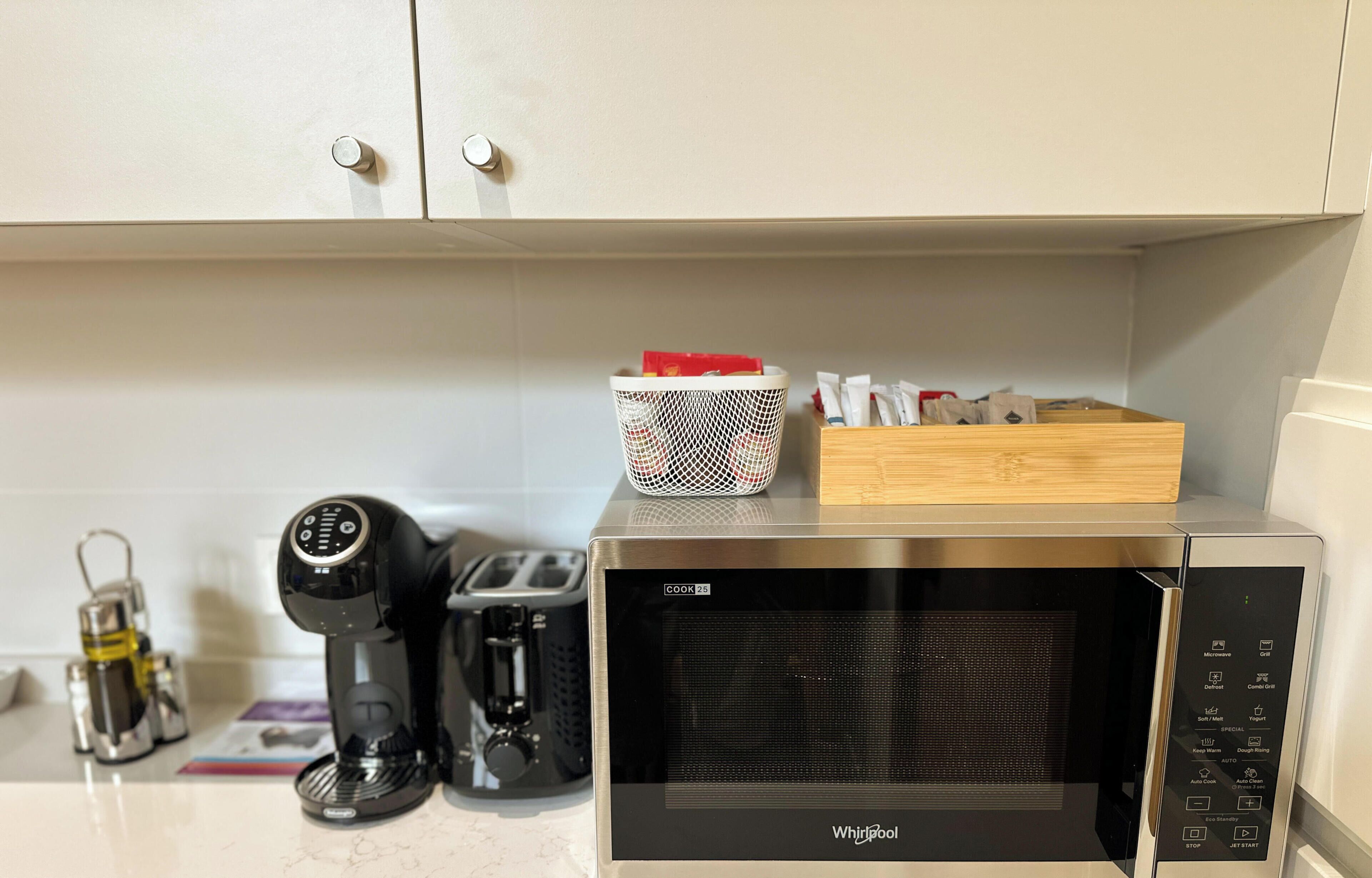 Cozinha equipada com micro-ondas, máquina de café e torradeira.