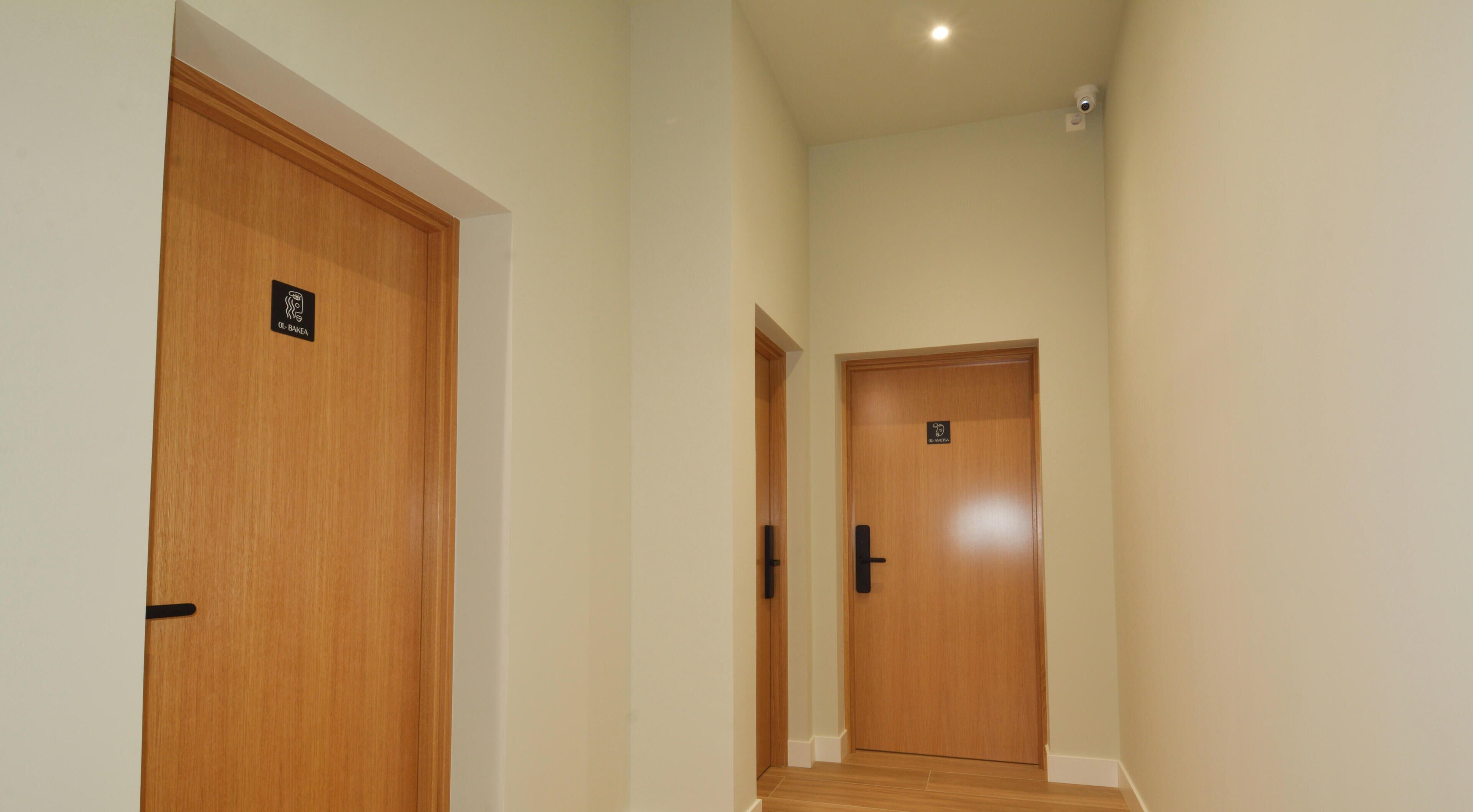 A hallway with two wooden doors, each with a sign above the door.