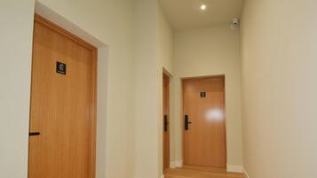 A hallway with two wooden doors, each with a sign above the door.