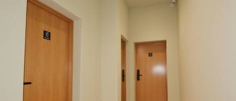 A hallway with two wooden doors, each with a sign above the door.