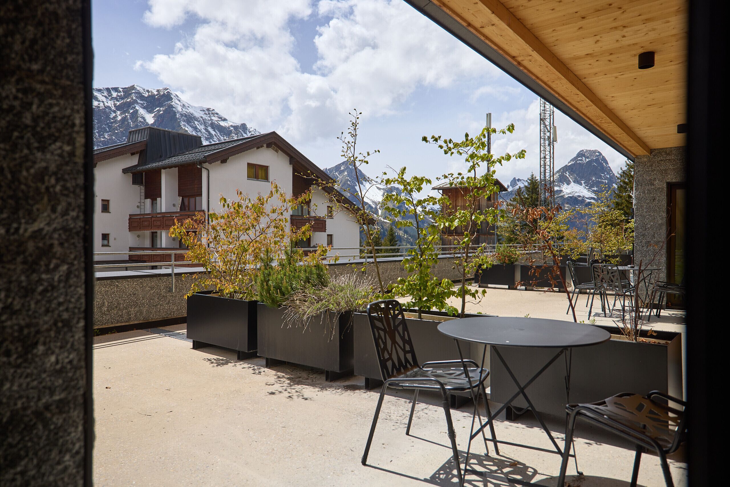 Eine Terrasse mit Tisch und Stühlen mit Blick auf eine Berglandschaft.