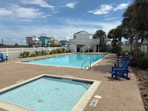 A swimming pool with a white fence, blue chairs, and a staircase leading to a building. - Sausalito Beach Retreat | Pool | Beach | Relax (Galveston)