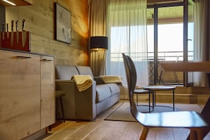 A modern living room with a sofa, a chair, a small table, and a cabinet.