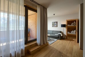 Een moderne woonkamer met een bank, een bijzettafeltje en een boekenkast.
