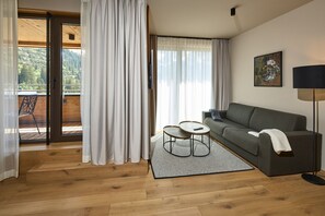 Una sala de estar moderna con un sofá gris, una mesita de centro redonda y una lámpara de pie.
