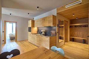 Una cocina moderna con armarios de madera, horno empotrado y cafetera.