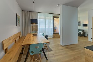 Un comedor moderno con una mesa de madera, sillas y una lámpara colgante.