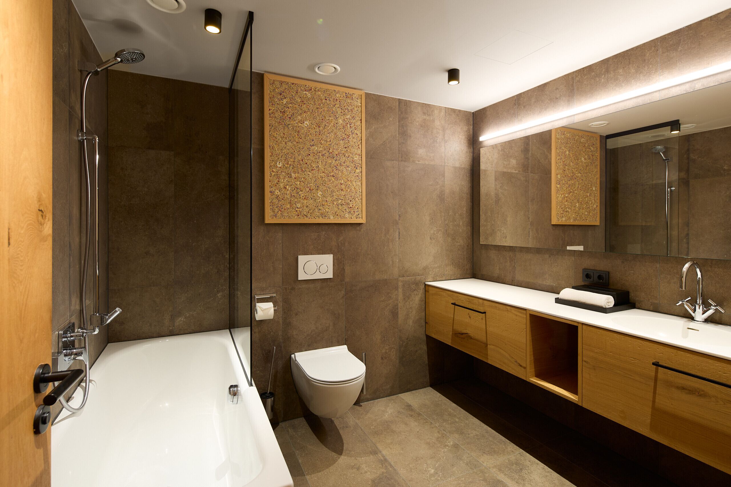 Ein modernes Badezimmer mit Badewanne, Toilette, Waschbecken und Dusche.