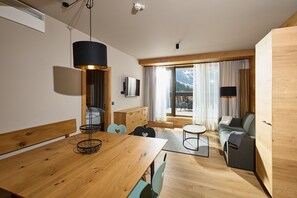 Ein modernes Interieur mit einem Holzespeisetisch, einer Couch und einem an der Wand befestigten Fernseher.