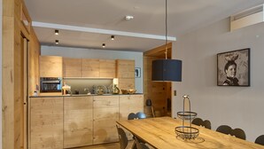 A modern kitchen with wooden cabinets and a central island. - 8030 Mountain Residence Grand 30 (Schröcken)
