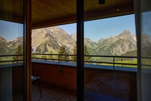 A room with a large window offering a mountain view. - 8033 Alpin Retreat 33 (Schröcken)
