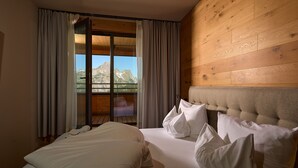 A hotel room with a bed, a window with curtains, and a view of mountains. - 8033 Alpin Retreat 33 (Schröcken)