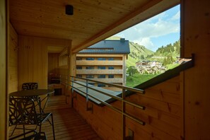 Ein Holzinnenraum mit einem Balkon mit Blick auf eine Berglandschaft.