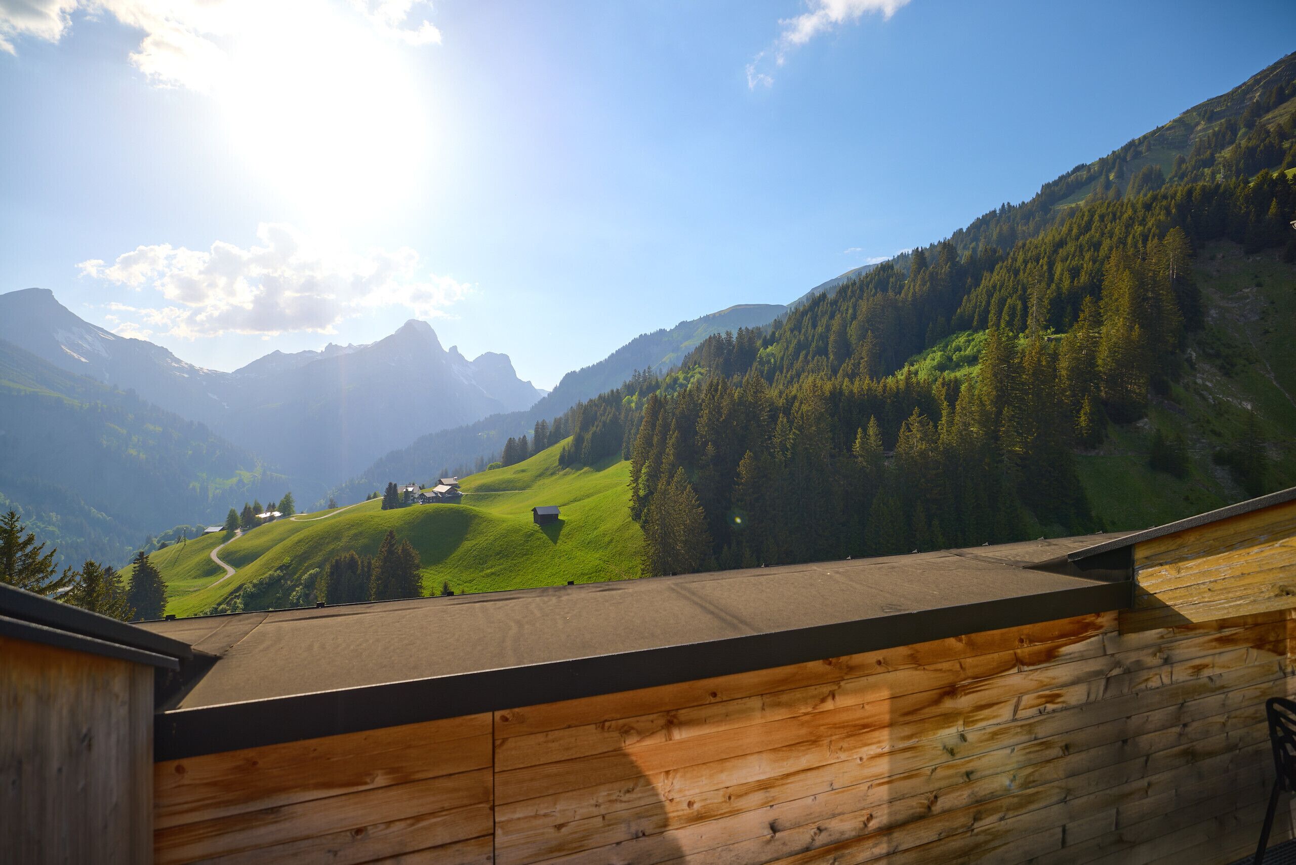 A wooden cabin with a view of a mountainous landscape.
