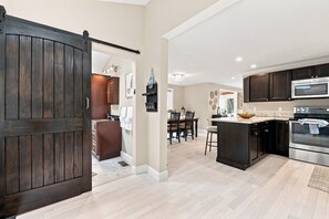 A modern kitchen with dark wood cabinets, a large island, and stainless steel appliances. - Lake Winnipesaukee Retreat | Private Beach | Dock (Alton)