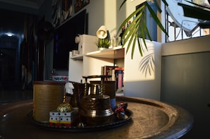 A room with a round table, a bookshelf, and a potted plant.