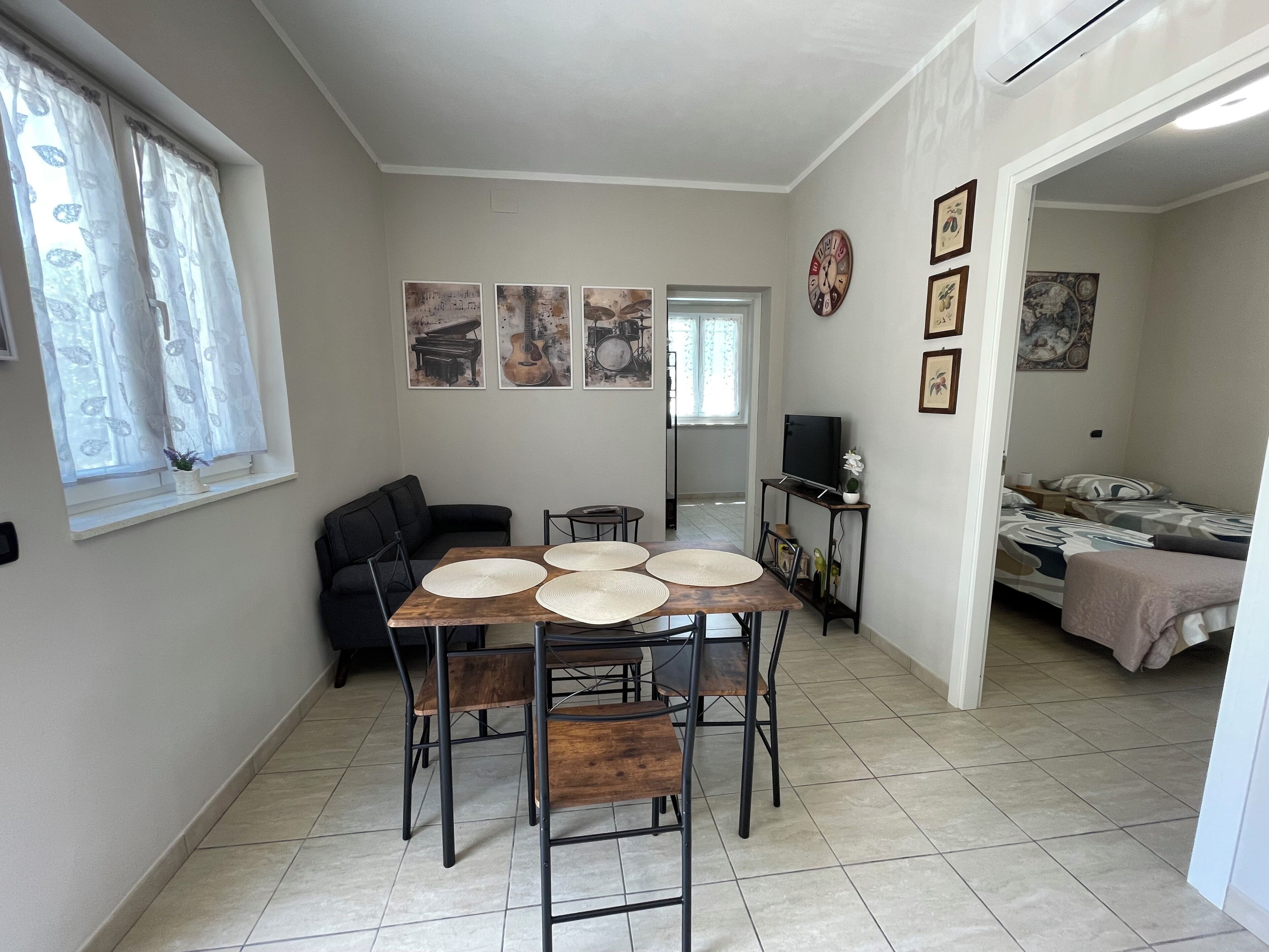 Un espace de vie compact comprenant un coin repas, un canapé, un téléviseur et un lit.
