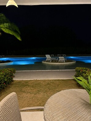 A nighttime pool area with lounge chairs and a pathway leading to the pool. - Luxury 1-Br Condo at Hard Rock Punta Cana — Resort Living, 15 mins from Downtown (Punta Cana)