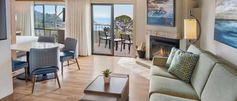 Habitación de hotel con zona de estar, comedor y chimenea.