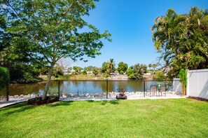A fenced outdoor area with a pond, a bench, and a sign indicating private property.
