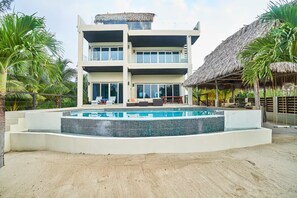 Un edificio de dos pisos con piscina delantera.