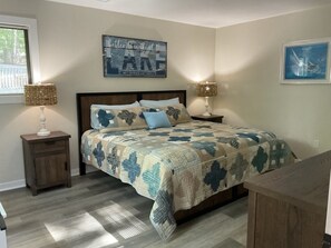 A bedroom with a bed, two nightstands, a wall-mounted lamp, and a framed picture. - Wake at the Lake in the Fall! What a beautiful, colorful time to enjoy SML!  (Moneta)