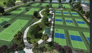 A tennis facility with multiple courts, pathways, and surrounding greenery.
