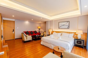 A hotel room with a bed, bedside tables, a sofa, a small table, and a chair. - Aesthetic Hotel (Krung Thep Maha Nakhon)