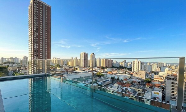 Ein Hochhaus mit Pool auf dem Dach und Blick auf die Skyline.