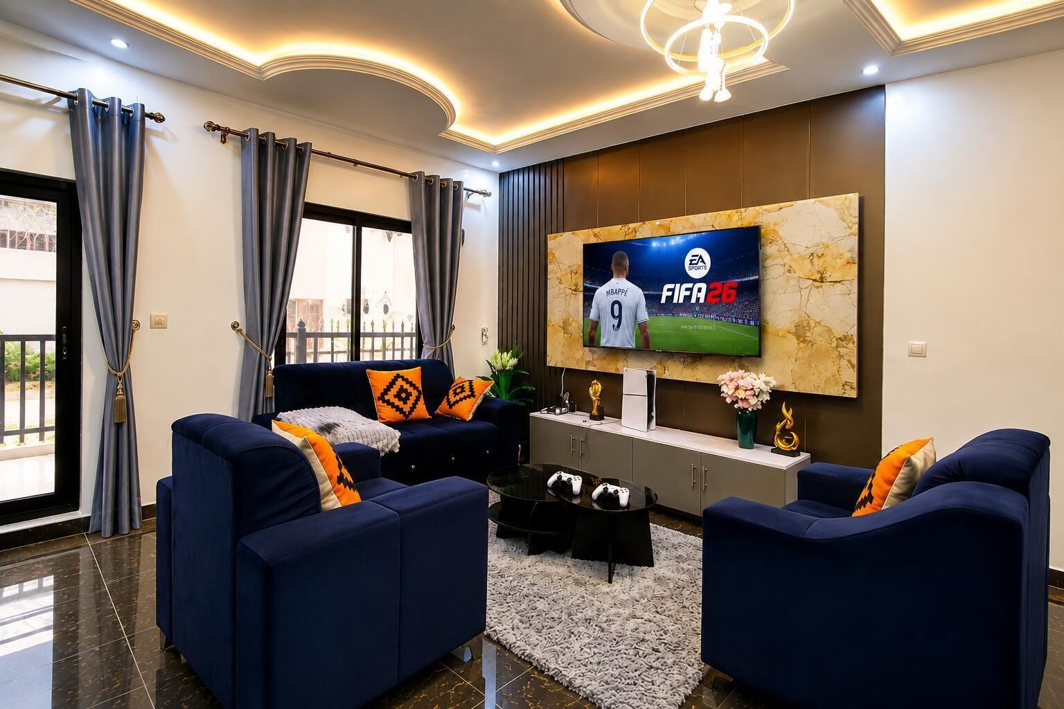 Un salon moderne doté d’un grand écran de télévision diffusant un événement sportif, d’un ensemble de canapés et d’un élément décoratif mural.