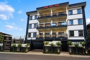 Um hotel com vários andares, varandas, salão de conferências e uma casa de hóspedes.