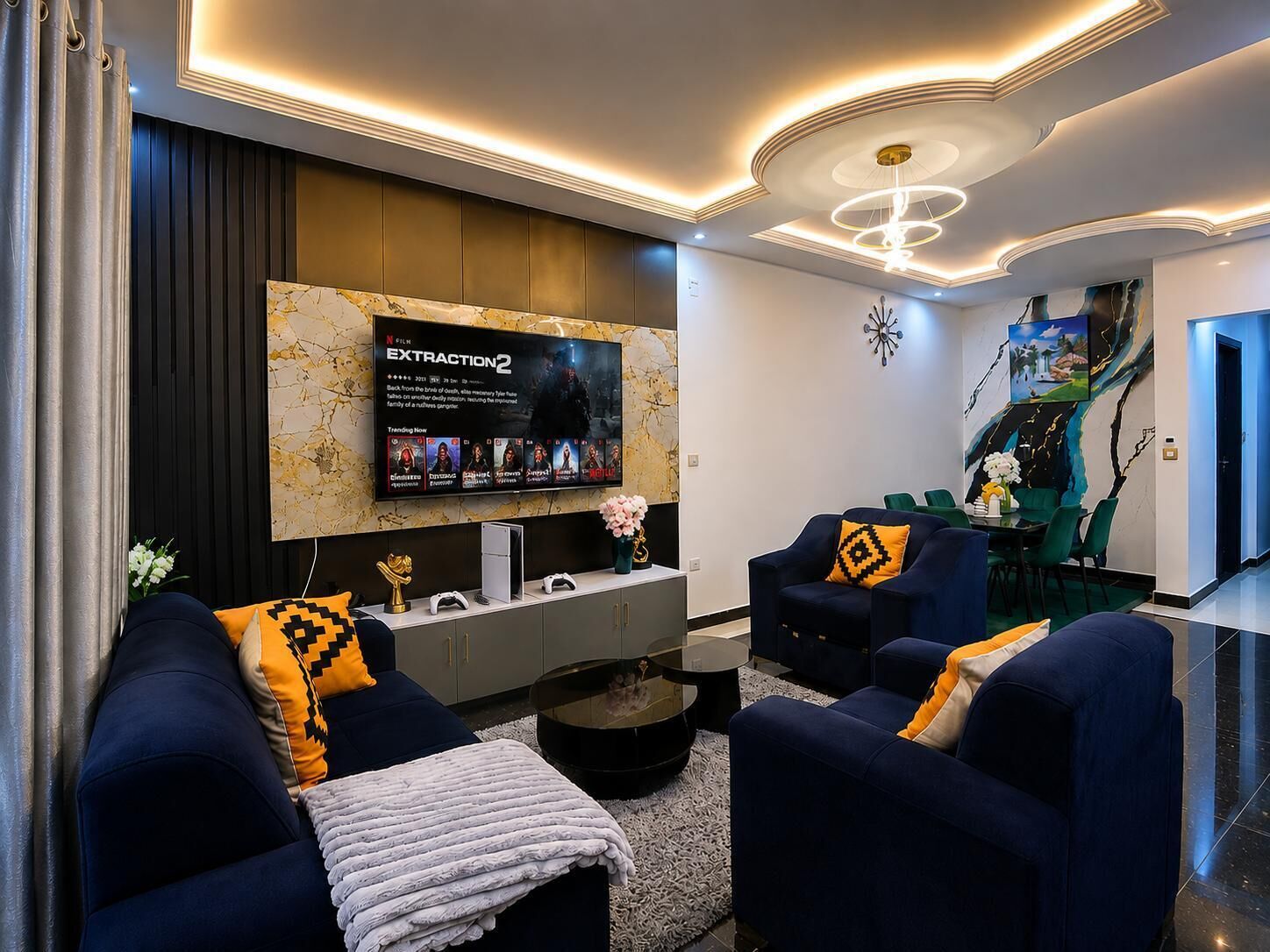 Un soggiorno moderno con TV a schermo piatto, divani scuri, un tavolino da caffè e un elemento decorativo a parete.