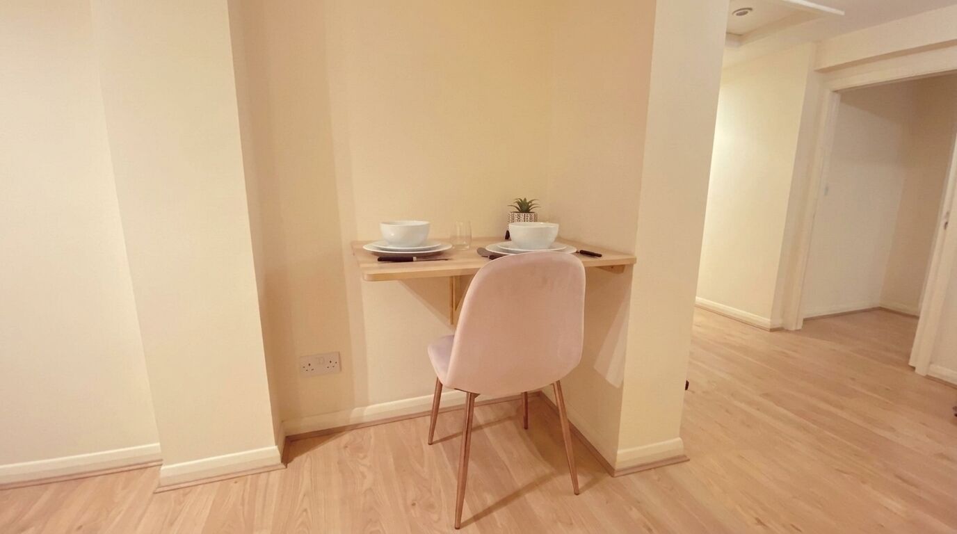 Un petit coin repas avec une table, une chaise et une plante en pot.