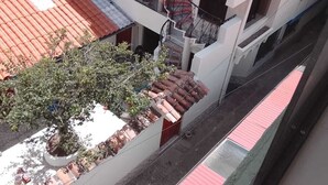 A multi-story building with a red-tiled roof, a staircase, and a small tree in a planter. - Terrific 5-bedroom house in charming Cusco for your getaway (Cusco)