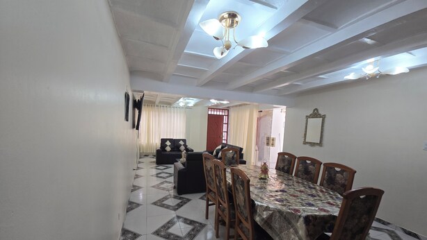 A dining area with a patterned floor, a dining table with chairs, and a ceiling fan. - Terrific 5-bedroom house in charming Cusco for your getaway (Cusco)