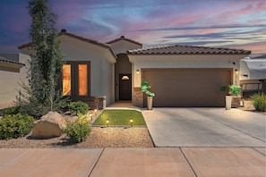 A residential house with a garage, a driveway, and a well-maintained lawn. - The Gibraltar Retreat at Red Hawk (Las Cruces)