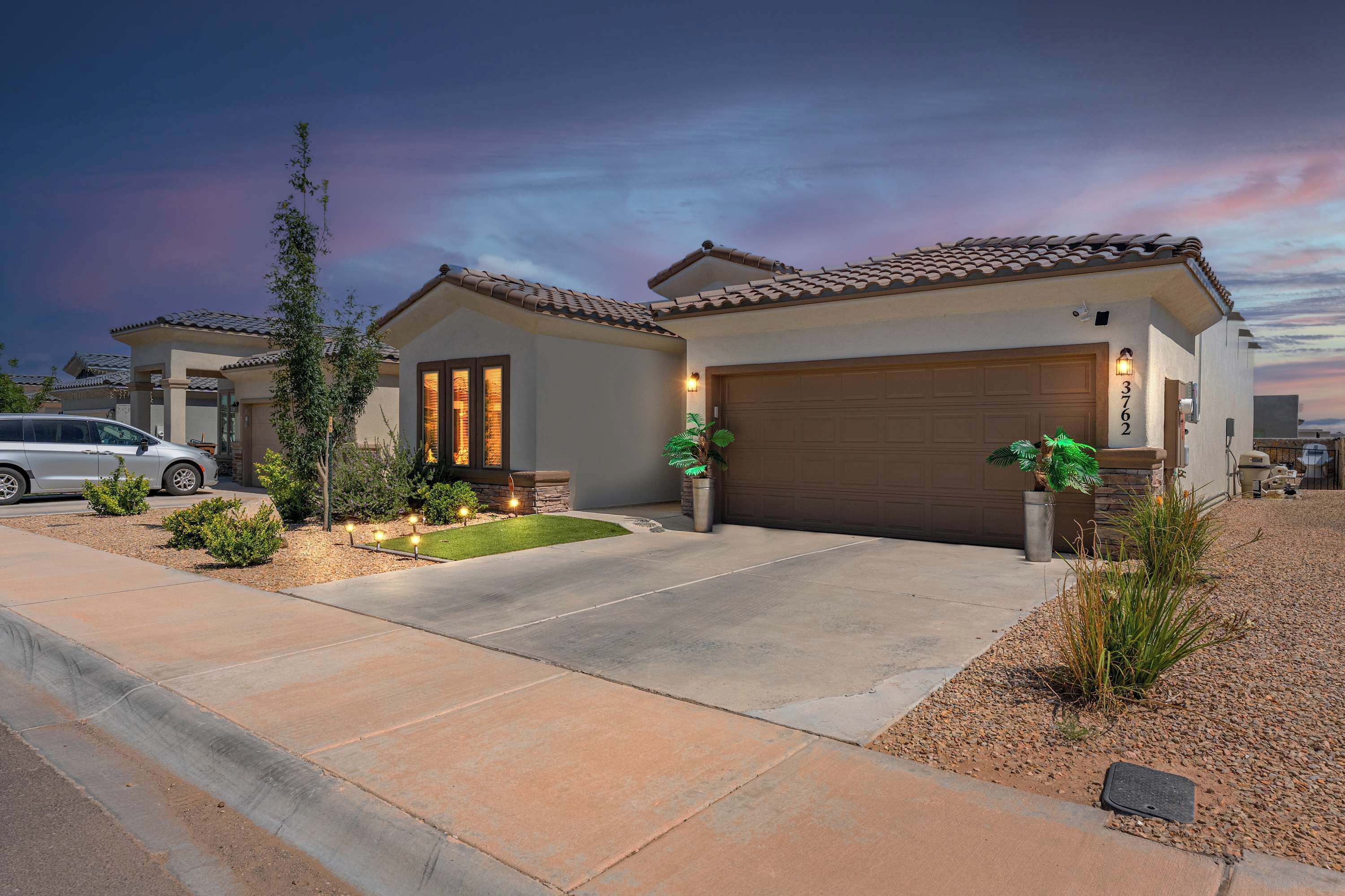 A residential property with a two-car garage, a landscaped front yard, and a driveway leading to the entrance.