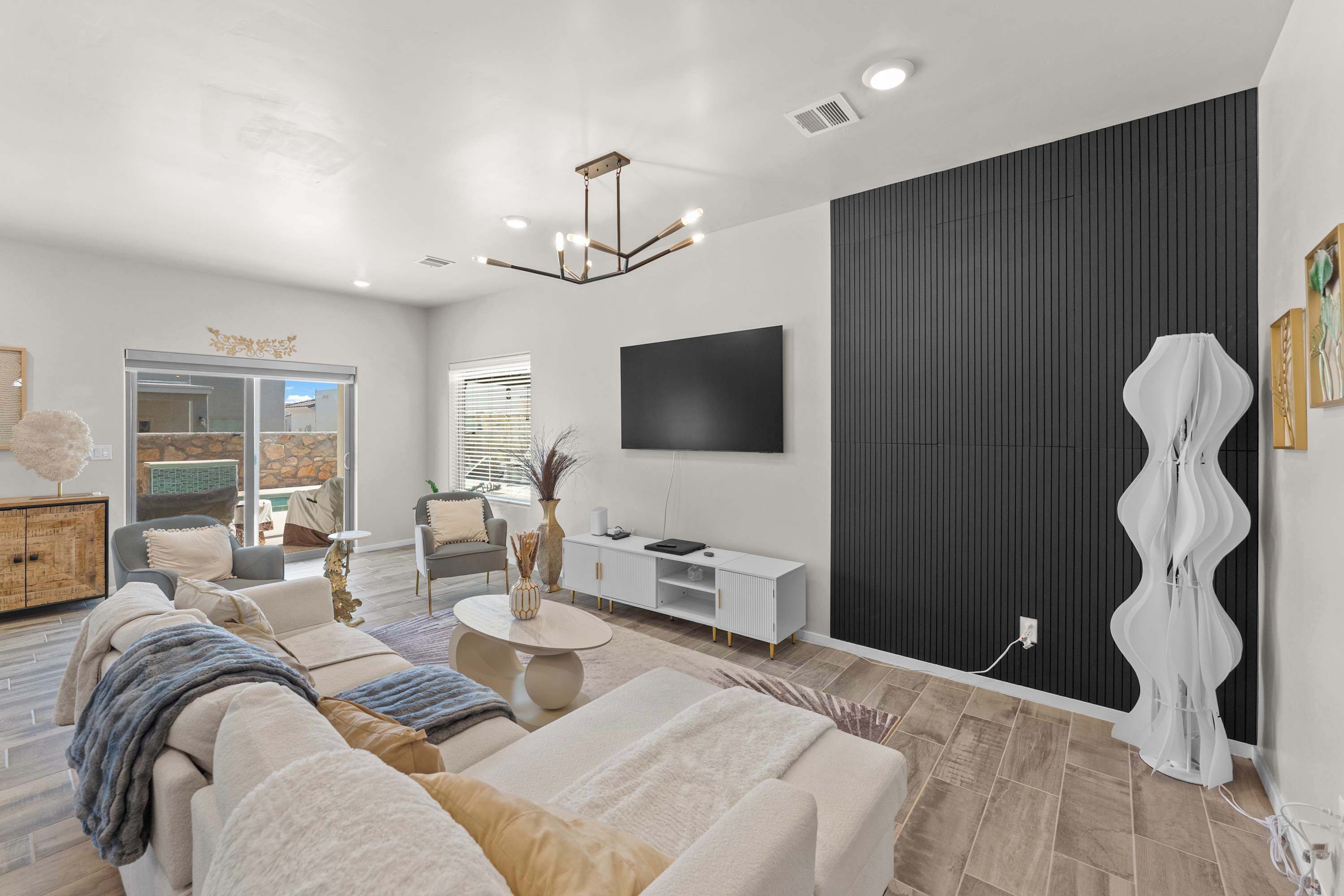 A modern living room with a sofa, coffee table, and a flat-screen TV mounted on the wall.